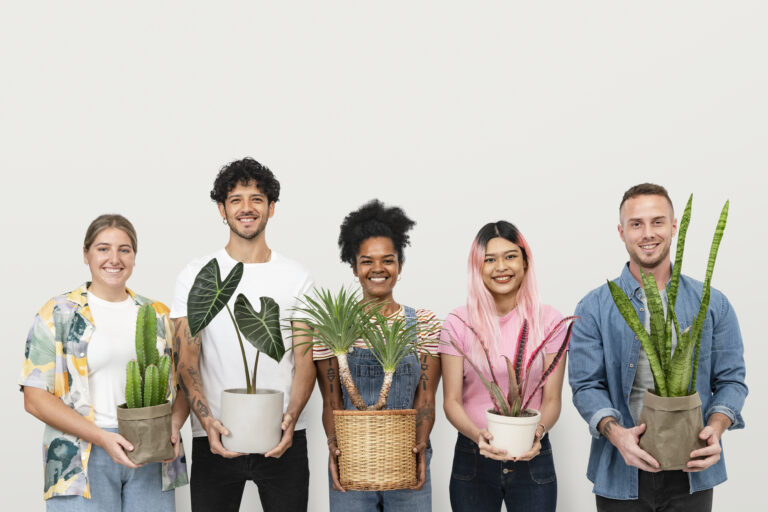 Diverse group of five smiling young adults proudly holding various potted indoor plants against a neutral background. Represents the inclusive community and career opportunities unlocked by Horticultural Therapy Certification 2025