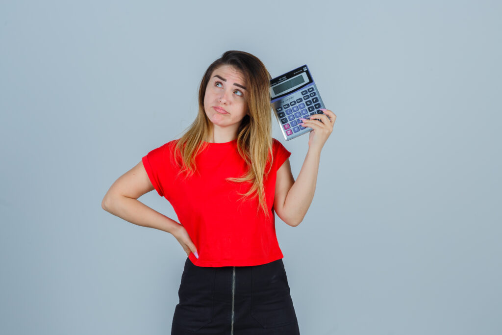 Horticultural Therapy Certification Cost 2026-young female in t-shirt, skirt holding calculator and looking pensive , front view.