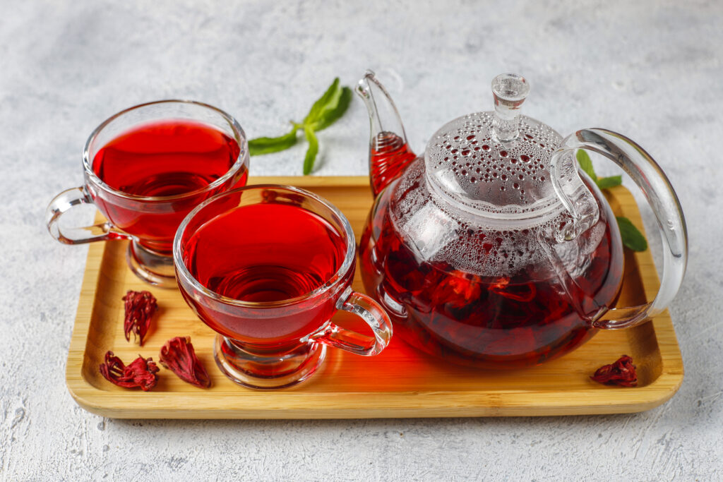 Hot Hibiscus Rooibos (Red Tea) in a glass mug and glass teapot.