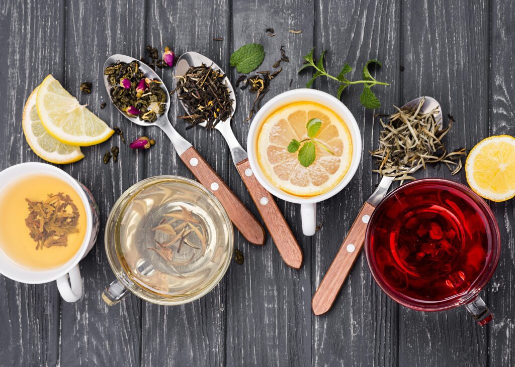 cups of tea and herbs next to each other on a table