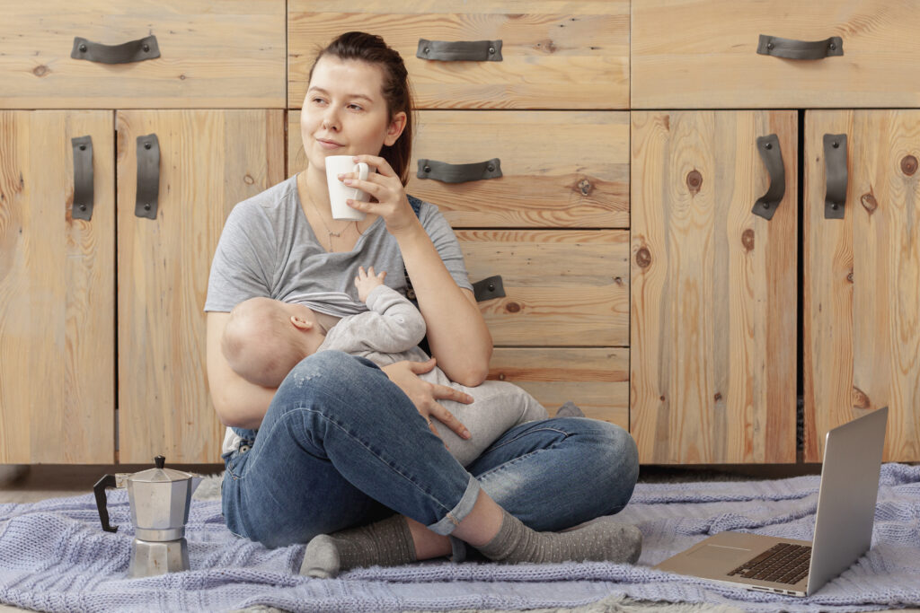 to Increase Milk Supply-Mother breastfeeding baby while drinking lactation tea to naturally increase milk supply