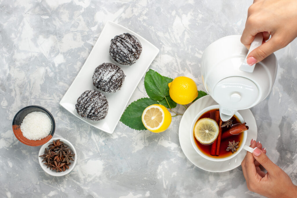 BREASTFEEDING TEA RECIPES-top-view-of-delicious-chocolate-cakes-small-round-shaped-with-lemon-and-a-cup-of-tea-on-a-light-white-surface-cookie-fruitcake-sugar-cookie-sugar