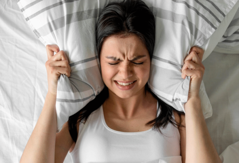 plants for sleep ,Frustrated woman in bed covering her ears with a pillow, suffering from insomnia